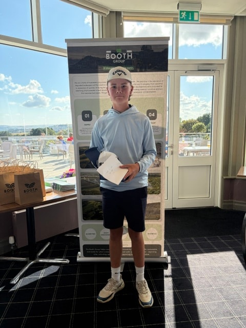 Junior golfer with prize at the Booth Group display